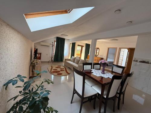 a living room with a wooden table and chairs at Belareca Garden in Mehadia