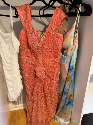 a red dress is hanging on a rack at Cozy ATL Suite with Kitchenette in Atlanta