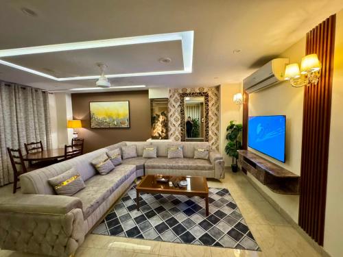 a living room with a couch and a tv at Bella Boutique Hotel Near Centaurus Mall - LMY Hospitality Islamabad in Islamabad