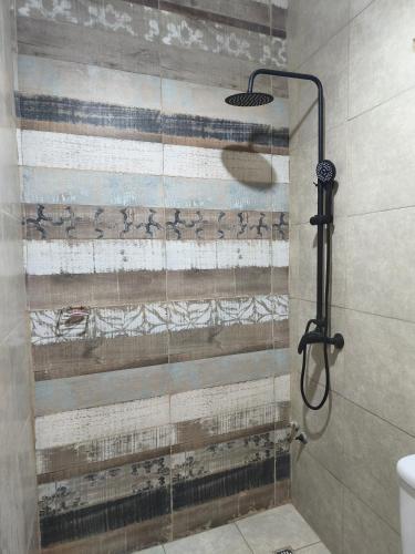a shower with a glass door in a bathroom at Urku Runa in Humahuaca