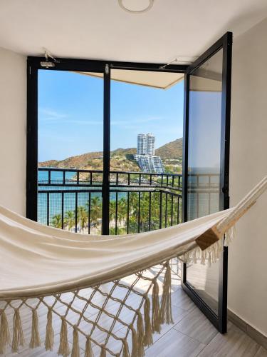 a hammock on a balcony with a view of the ocean at Apartamento 10c Edf.Playa in Santa Marta