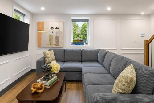 a living room with a gray couch and a table at Cambridge Designer Home Harvard MIT Boston in Cambridge