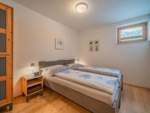 a bedroom with a large bed and a night stand at IndieBerge in Mittersill