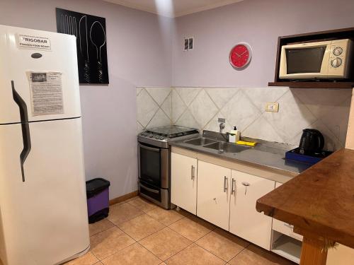 a kitchen with a refrigerator and a sink at Casa Llao alojamiento de montaña in San Carlos de Bariloche