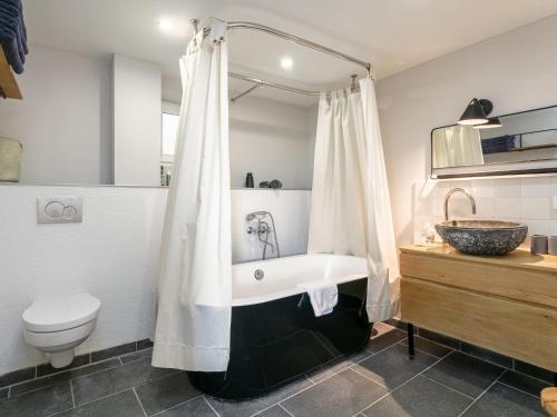 a bathroom with a tub and a toilet and a sink at MAYR 74 in Wörgl