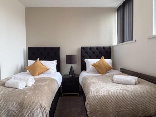 two beds sitting next to each other in a bedroom at Sunderland Central 2BR Apartments in Sunderland