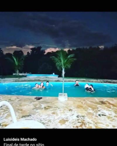 a group of people in a swimming pool at night at Regional Park in Rafard