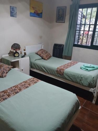 a bedroom with two beds and a table with a mirror at Casa amigable dos habitaciones cuatro lugares in Rosario
