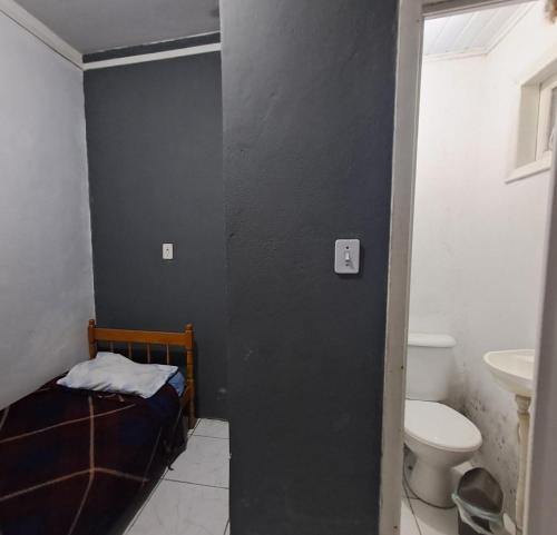 a bathroom with a bed and a toilet and a sink at Pousada econômica puc in Porto Alegre