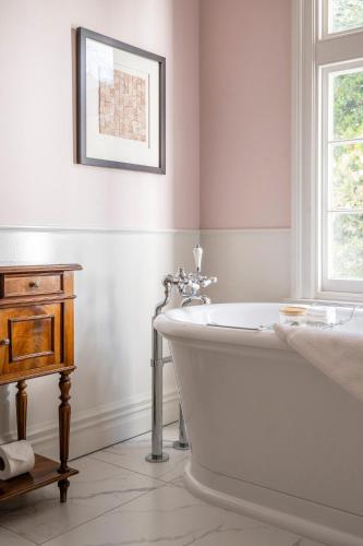 a white bath tub in a bathroom with a window at Otahuna Lodge in Christchurch