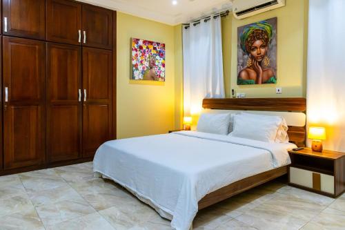a bedroom with a large bed and a painting on the wall at MAAT Luxury Homes in Accra