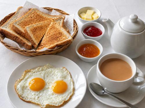 a plate with eggs and toast and a cup of coffee at We Hotels Islamabad Airport in Islamabad