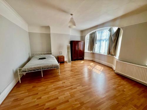 a bedroom with a bed and a wooden floor at East Croydon Train Station in Croydon