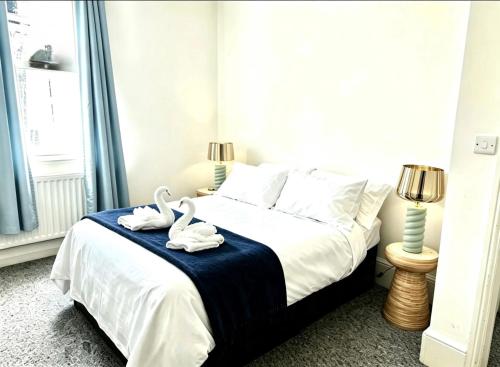 two swans sitting on a bed in a bedroom at St Leonards in Hollington