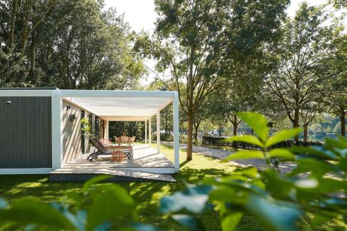 a pavilion with a table and chairs in a yard at Forest Cube 4 persons #1210 in Maasbree