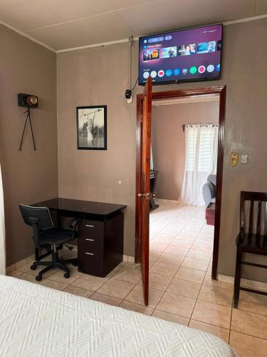 a room with a desk and a television on the wall at Hospedaje Ejecutivo Toronjal II in La Ceiba