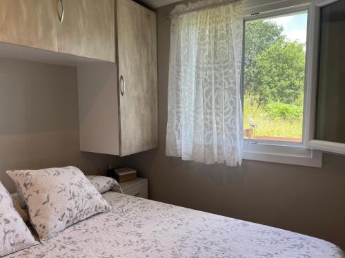 a bedroom with a bed and a window at La Cabaña del aviador in Feás