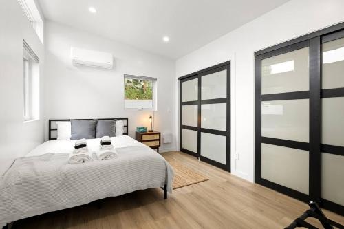 a bedroom with a bed with white sheets and black doors at Spacious 1BR 1bath near DTLA in Los Angeles