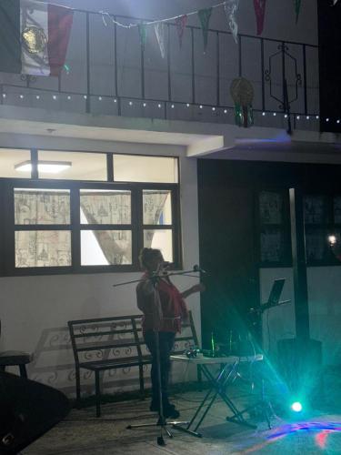 a person standing on a stage with a microphone at Quinta Kendriel in Tezoyuca