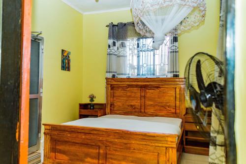 a bedroom with a wooden bed and a fan at The new home in Moshi