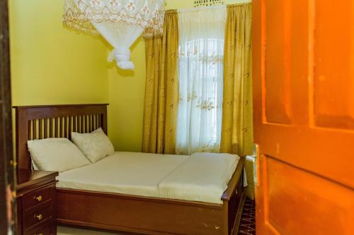 a small bed in a room with a window at The new home in Moshi