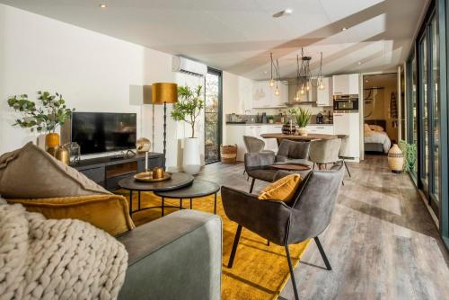 a living room with a couch and chairs and a kitchen at Forest Cube 2 persons #628 2 persoons in Maasbree