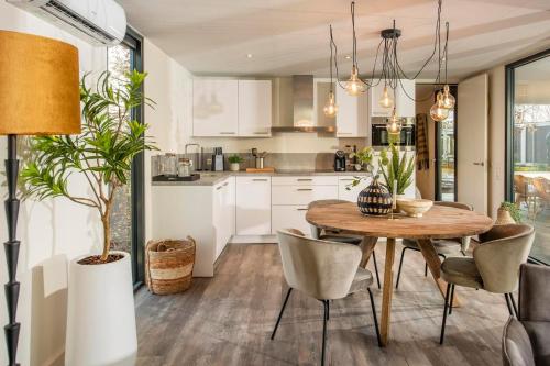 a kitchen and dining room with a wooden table and chairs at Forest Cube 2 persons #628 2 persoons in Maasbree
