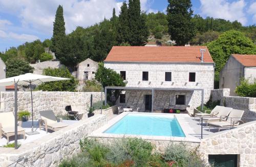 a stone house with a swimming pool in front of a building at Hedera Estate, Villa Hedera VIII in Orasac