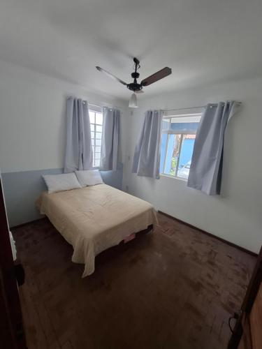 a bedroom with a bed and a ceiling fan at Casazul in Lavrinhas