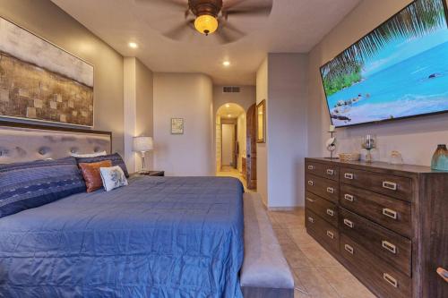 a bedroom with a blue bed and a tv on the wall at Bella Sirena 502-A Beachfront Luxury - Best Views, Best Location in Puerto Peñasco