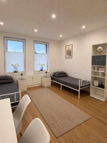 a bedroom with two beds and two windows at H&R Suite - Bielefeld Central in Bielefeld