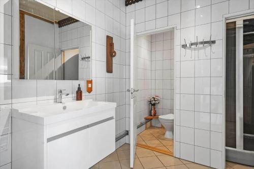 a white bathroom with a sink and a toilet at 6048-Stege-Kostervej-48 in Stege