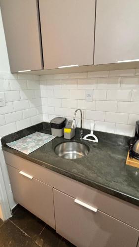 a kitchen counter with a sink in a kitchen at Palladium Refúgio - 500 metros da Praia, Perto do Shopping, Wi-Fi, Piscina e Garagem in São Vicente