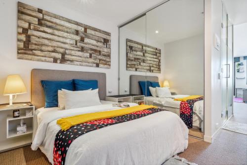 a bedroom with two beds and a mirror at Seaside Studio Apartment in Frankston, Melbourne in Frankston