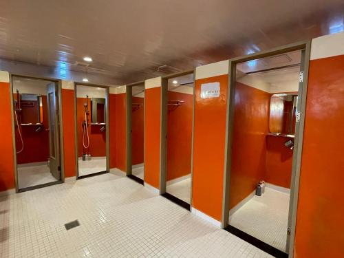 a row of stalls in a bathroom with orange walls at Baramgot Guesthouse in Gyeongju