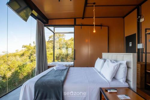 a bedroom with a bed and a large window at Charming chalet with fireplace and hot tub! VST045 in Annitapolis