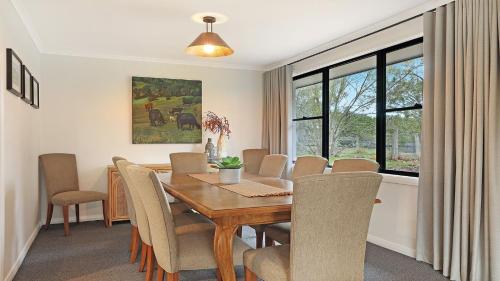 a dining room with a wooden table and chairs at Mirambeena in Berrima