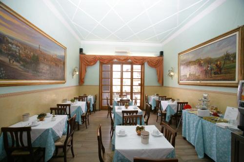 a restaurant with tables and chairs and paintings on the walls at Hotel Desirèe in Florence