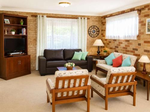 a living room with a couch and chairs at Seascape Carroll Avenue - close to Mollymook Beach in Mollymook