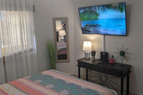 a bedroom with a bed and a desk with a television on the wall at Princesa de Penasco B208 - Family Beach Getaway in Puerto Peñasco