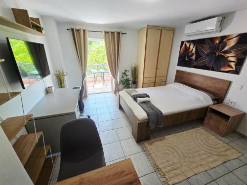 a bedroom with a bed and a kitchen with a table at The Garden Studio - Spacious Balcony in Lamía