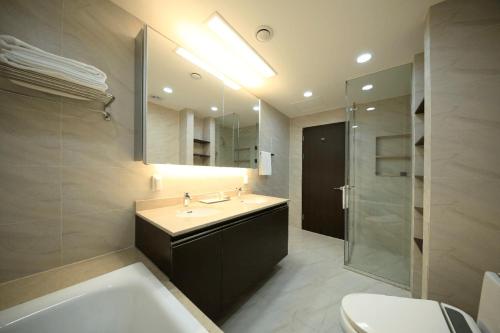 a bathroom with a sink and a tub and a toilet at Orakai Insadong Suites in Seoul