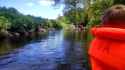 a young boy is in a boat on a river at Asaa Camping & Cottages in Aså