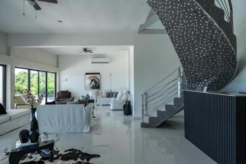 a white living room with a staircase and a living room with at Emotions by Ironshore in Montego Bay