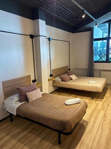 a room with two beds and a large window at Albergue HR in Sarria