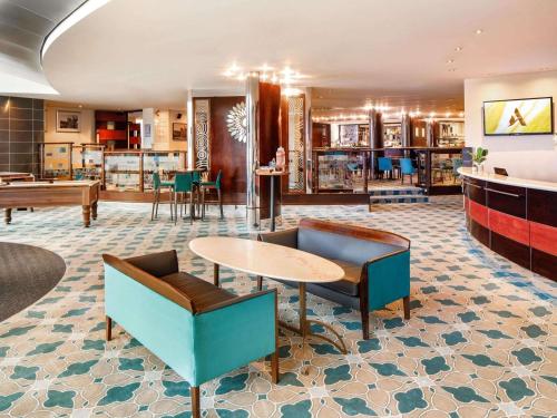 a hotel lobby with a table and chairs at Mercure Chester Abbots Well Hotel in Chester