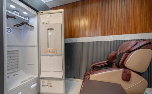 a small room with a chair and a refrigerator at Andong Win Hotel in Hoam-dong