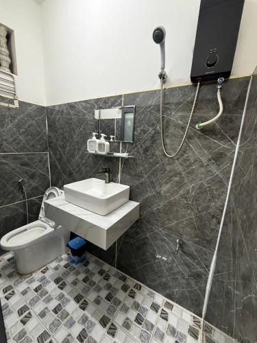 a bathroom with a shower and a sink and a toilet at TUNI Hotel in Long Bình
