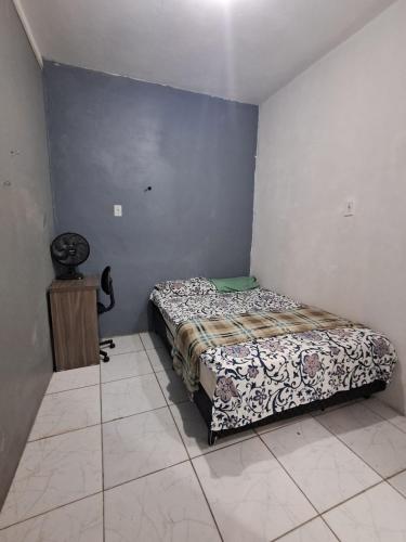 a small bedroom with a bed and a table at Pousada econômica puc in Porto Alegre
