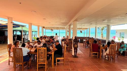 a group of people sitting at tables in a restaurant at hostal EMBAMAR in Palomino